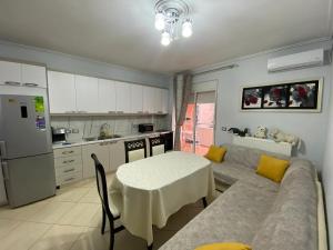 a kitchen with a couch and a table in a kitchen at Olive Tree Apartment in Sarandë