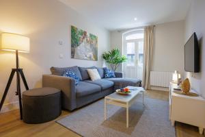 ein Wohnzimmer mit einem blauen Sofa und einem Tisch in der Unterkunft Apartamento Pagasarri, Bilbaohost in Bilbao