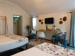 a bedroom with two beds and a desk with a television at Kwetu Home - Sagana PAY BEFORE ARRIVAL in Sagana