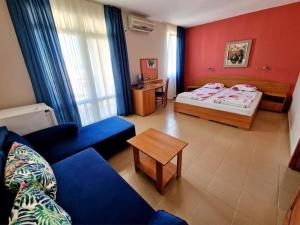 um quarto com duas camas, um sofá e uma mesa em Family Hotel Selena em Nessebar
