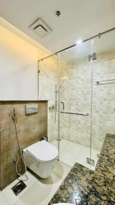 ein Bad mit einem WC und einer Glasdusche in der Unterkunft One bed appartment in GOLDCrest DHA Lahore in Lahore