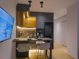 PIN Apartments في تيرانا: مطبخ مع طاولة وكرسيين وكاونتر