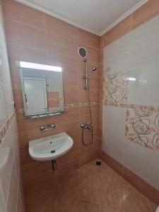 uma casa de banho com um lavatório e um chuveiro em Family Hotel Selena em Nessebar