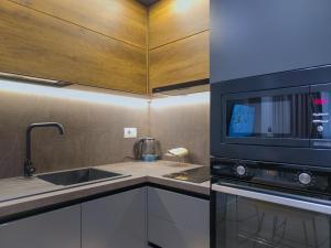 cocina con fregadero y microondas en PIN Apartments en Tirana