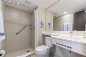 y baño con aseo, lavabo y ducha. en City Express by Marriott Xalapa en Xalapa