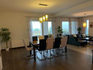 Balatonview - villa Myriam في Nemesbük: غرفة معيشة مع طاولة طعام وكراسي