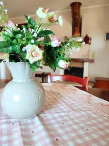 a white vase with flowers in it sitting on a table at Il Bagolaro Casa Vacanze in Sulmona