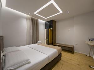 Schlafzimmer mit einem großen weißen Bett und einem Dachfenster in der Unterkunft PIN Apartments in Tirana