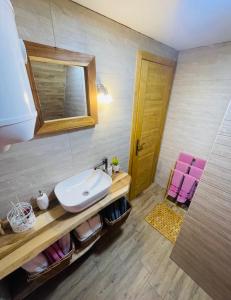 a bathroom with a sink and a mirror and two pink towels at A Frame Houses ANS Zabljak in Žabljak +47 photos