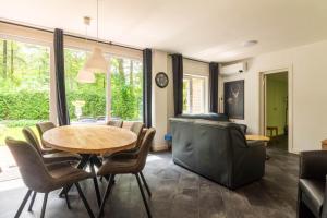a dining room with a table and chairs at Holiday Home Eekhoornbosch in Otterlo