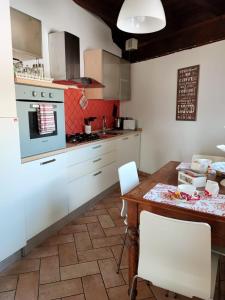 a kitchen with white cabinets and a wooden table at Il Bagolaro Casa Vacanze in Sulmona