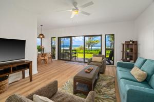 sala de estar con sofá azul y TV de pantalla plana en Kauai Kaha Lani by Coldwell Banker Island Vacations, en Lihue
