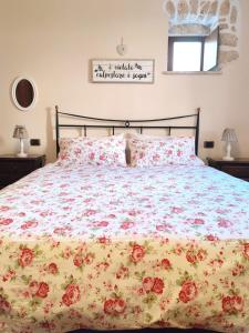 un letto con copriletto e cuscini floreali; di Il Bagolaro Casa Vacanze a Sulmona