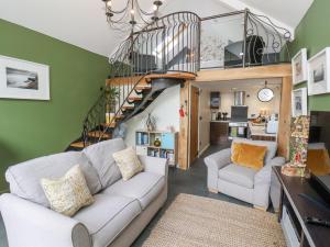uma sala de estar com um sofá e uma escada em The Nail Shed em Scarborough