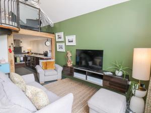 uma sala de estar com um sofá e uma televisão em The Nail Shed em Scarborough