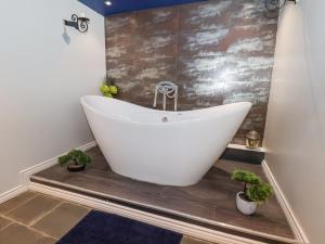 a white bath tub in a bathroom with plants at The Nail Shed in Scarborough +33 photos