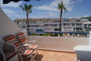 a balcony with two chairs and a building at Apartamentos Marineu Voramar in Alcossebre