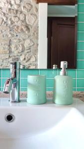 dos tazas verdes sentadas en el lavabo del baño en Il Bagolaro Casa Vacanze en Sulmona