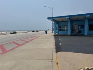 un estacionamiento vacío junto a un edificio azul en Econo Lodge Galveston Seawall en Galveston