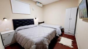 1 Schlafzimmer mit 2 Betten und einer weißen Wand in der Unterkunft Departamento Capital in San Fernando del Valle de Catamarca