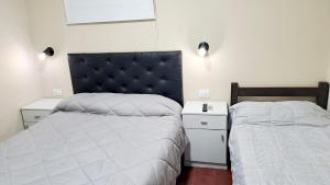 een slaapkamer met 2 bedden en een hoofdeinde bij Departamento Capital in San Fernando del Valle de Catamarca