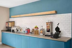a kitchen with a blue counter top with food on it at Comfort Suites Shenandoah-The Woodlands in The Woodlands
