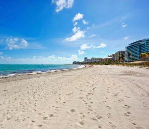 una spiaggia con impronte di piedi nella sabbia e nell'oceano di best life a Miami
