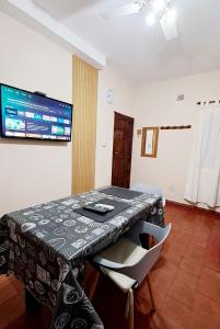 a dining room with a table and a television on the wall at Departamento Capital in San Fernando del Valle de Catamarca