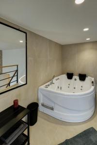a large white tub in a bathroom with a mirror at Sunflower Apartment in Belgrade +14 photos