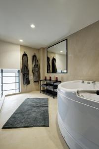 a large bathroom with a tub and a mirror at Sunflower Apartment in Belgrade