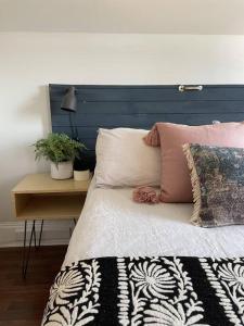a bed with a blue headboard and a table with pillows at Hill Street Hangout in Picton