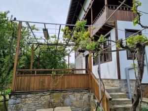 uma casa com uma varanda de madeira e escadas em Arbanassi Hotel em Arbanasi