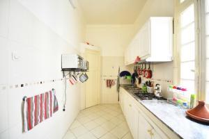 a kitchen with white cabinets and a counter top at Cosy Art Deco Apart in Casablanca