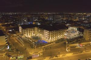 - une vue nocturne sur un grand bâtiment éclairé dans l'établissement Vidam Hotel Aracaju - Transamerica Collection, à Aracaju