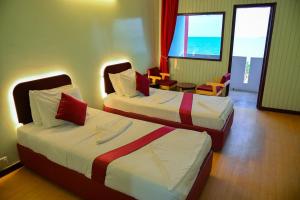 um quarto de hotel com duas camas e uma mesa e cadeiras em SIESTA HOTEL em Djibouti