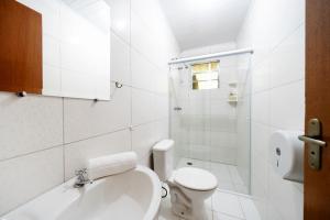 ein weißes Bad mit einem WC und einer Dusche in der Unterkunft Recanto Julubi Atibaia in Atibaia