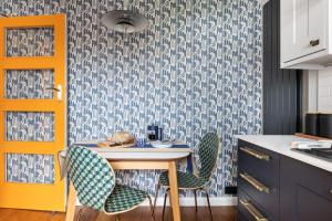 a kitchen with a table with chairs and a yellow door at The Lorelei 2BR Mid-Century Modern Stylish Apartment in Brighton & Hove