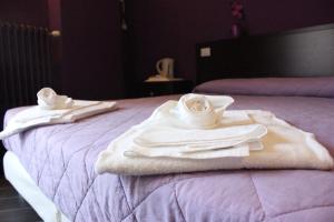 a hotel room with towels and dishes on a bed at B&B Fanzago in Bergamo