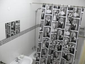 a bathroom with a shower curtain with a group of photos at Nations Rooms in Lisbon