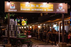 a restaurant at night with a horse drawn cart in front at Guarujá Praia Hotel Econômico in Guarujá