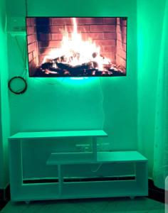 a living room with a fireplace in front of a tv at Palm homes in Mutomo