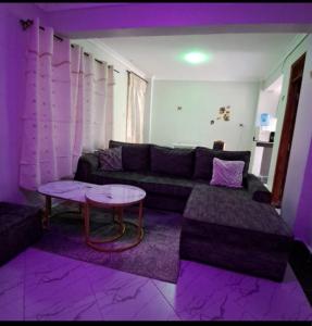 a living room with a couch and a table at Palm homes in Mutomo