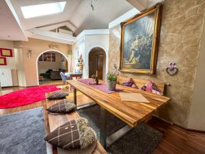 salon z drewnianym stołem i obrazem na ścianie w obiekcie Stadt & See Appartement Penthouse inkl MIC Card w mieście Spittal an der Drau