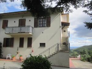 a large white building with stairs and a balcony at Appartamento Panoramico in Montepulciano
