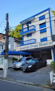 グアルジャにあるGuarujá Praia Hotel Econômicoのホテル前の駐車場に2台駐車