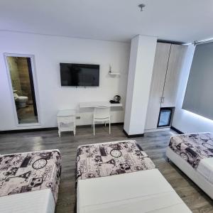 a white room with two beds and a table at Hotel Boutique Palacete in Bogotá