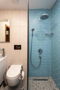 a bathroom with a toilet and a shower with blue tiles at TERRA GAİA Hotel in Gokceada Town