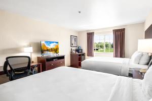 a hotel room with two beds and a television at Boarders Inn & Suites by Cobblestone Hotels - Shawano in Shawano