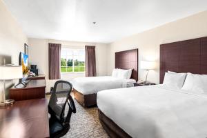 a hotel room with two beds and a window at Boarders Inn & Suites by Cobblestone Hotels - Shawano in Shawano