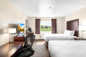 a hotel room with two beds and a desk at Boarders Inn & Suites by Cobblestone Hotels - Shawano in Shawano